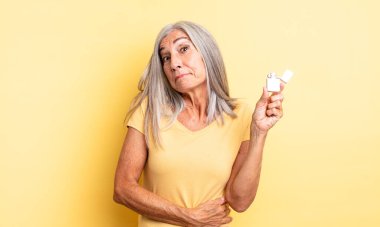 Orta yaşlı güzel bir kadın omuz silkiyor, kafası karışık ve kararsız. daha hafif kavram