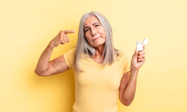 Orta yaşlı güzel bir kadın kafası karışık ve şaşkın hissediyor, deli olduğunu gösteriyor. daha hafif kavram