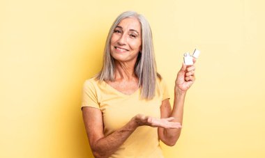 Orta yaşlı güzel bir kadın neşeli bir şekilde gülümsüyor, mutlu hissediyor ve bir konsept gösteriyor. daha hafif kavram