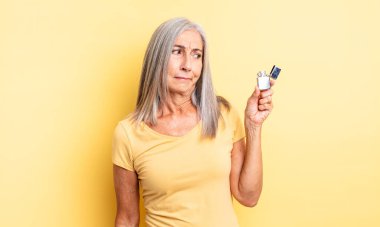 Orta yaşlı, güzel bir kadın üzgün, üzgün ya da kızgın ve yana bakıyor. daha hafif kavram