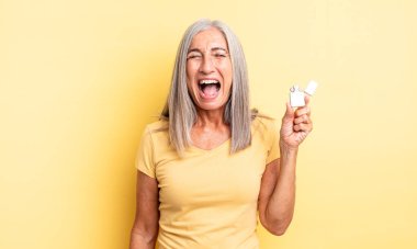 Orta yaşlı, güzel bir kadın agresif bir şekilde bağırıyor, çok kızgın görünüyor. daha hafif kavram