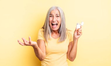 Orta yaşlı, güzel bir kadın sinirli, sinirli ve sinirli görünüyor. daha hafif kavram