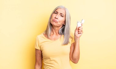 Orta yaşlı, güzel bir kadın üzgün ve mızmızlanıyor. Mutsuz bir bakışı var ve ağlıyor. daha hafif kavram