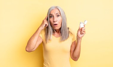 Orta yaşlı, güzel bir kadın şaşırmış görünüyor, yeni bir düşünce, fikir ya da konsept fark ediyor. daha hafif kavram