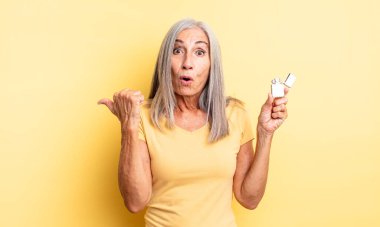 Orta yaşlı, güzel bir kadın inançsızlıktan şaşkın şaşkın bakıyor. daha hafif kavram