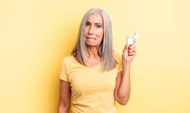 Orta yaşlı güzel bir kadın kafası karışmış ve şaşkın görünüyor. daha hafif kavram