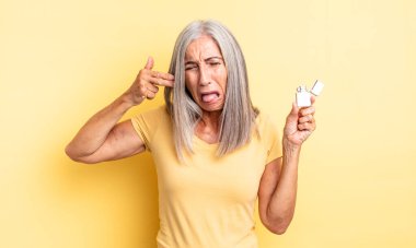 Orta yaşlı, güzel bir kadın mutsuz ve stresli görünüyor, intihar jesti silah işareti yapıyor. daha hafif kavram