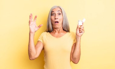 Orta yaşlı, güzel bir kadın ellerini havaya kaldırarak çığlık atıyor. daha hafif kavram