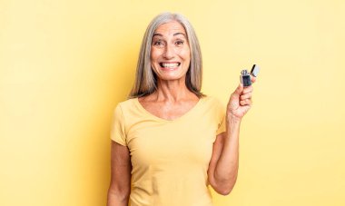 Orta yaşlı, güzel bir kadın mutlu ve hoş bir şekilde şaşırmış görünüyor. daha hafif kavram