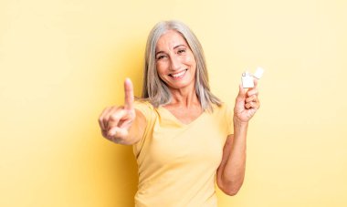 Orta yaşlı, güzel bir kadın gururla gülümsüyor ve kendinden emin bir numara oluyor. daha hafif kavram