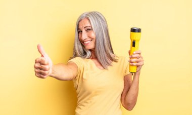 Orta yaşlı, güzel bir kadın gururlu, olumlu gülümsüyor. fener konsepti