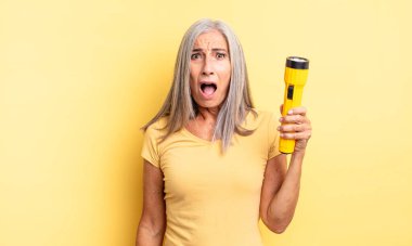 Orta yaşlı güzel bir kadın çok şaşırmış ya da şaşkın görünüyor. fener konsepti