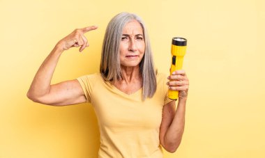 Orta yaşlı güzel bir kadın kafası karışık ve şaşkın hissediyor, deli olduğunu gösteriyor. fener konsepti