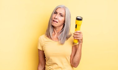 Orta yaşlı, güzel bir kadın şaşkın ve kafası karışık hissediyor. fener konsepti