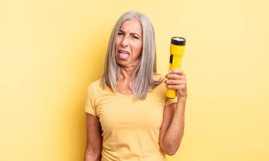 Orta yaşlı, güzel bir kadın iğreniyor, sinirleniyor ve dili dışarı çıkıyor. fener konsepti