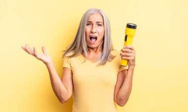 Orta yaşlı güzel bir kadın son derece şaşkın ve şaşırmış hissediyor. fener konsepti