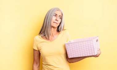 Orta yaşlı, güzel bir kadın üzgün, üzgün ya da kızgın ve yana bakıyor. boş sepet konsepti