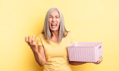 Orta yaşlı, güzel bir kadın sinirli, sinirli ve sinirli görünüyor. boş sepet konsepti