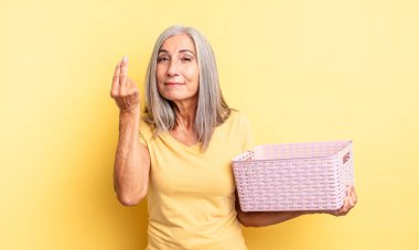 Orta yaşlı, güzel bir kadın kapiş ya da para hareketi yapıp sana ödemeni söylüyor. boş sepet konsepti