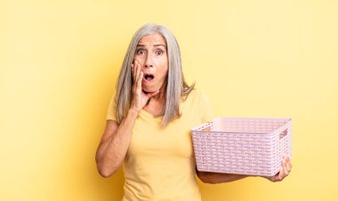 Orta yaşlı, güzel bir kadın şok olmuş ve korkmuş hissediyor. boş sepet konsepti