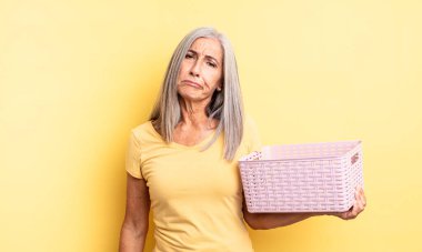 Orta yaşlı, güzel bir kadın üzgün ve mızmızlanıyor. Mutsuz bir bakışı var ve ağlıyor. boş sepet konsepti