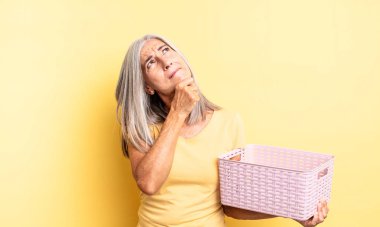 Orta yaşlı, düşünceli, kuşkulu ve kafası karışık bir kadın. boş sepet konsepti