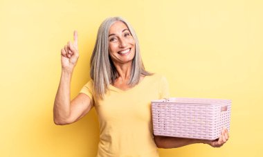 Orta yaşlı, güzel bir kadın bir fikri fark ettikten sonra mutlu ve heyecanlı bir dahi gibi hissediyor. boş sepet konsepti