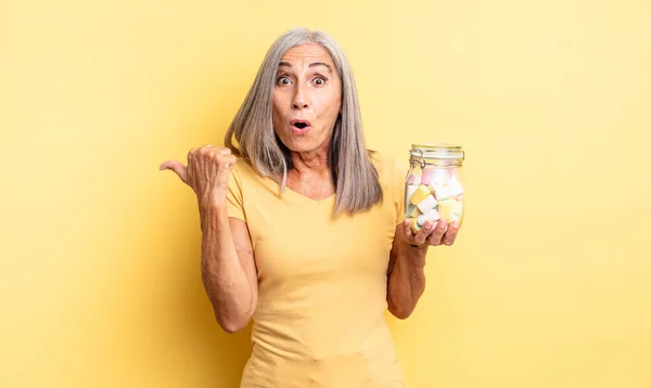 Middle Age Pretty Woman Looking Astonished Disbelief Candies Bottle Concept — Stock Photo, Image