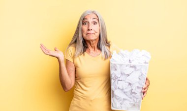 Orta yaşlı, güzel bir kadın şaşkın, şaşkın ve şüpheci hissediyor. kağıt toplar başarısızlık konsepti