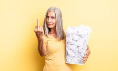 Orta yaşlı, güzel bir kadın sinirli, sinirli, asi ve agresif hissediyor. kağıt toplar başarısızlık konsepti