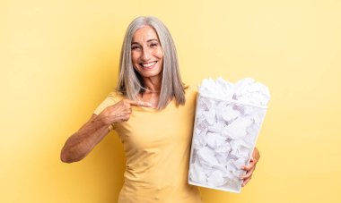 Orta yaşlı, güzel bir kadın heyecanlı ve şaşırmış görünüyor. kağıt toplar başarısızlık konsepti