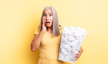 Orta yaşlı, güzel bir kadın şok olmuş ve korkmuş hissediyor. kağıt toplar başarısızlık konsepti