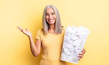 Orta yaşlı, güzel bir kadın kendini mutlu hissediyor. Bir çözüm ya da fikir bulduğuna şaşırıyor. kağıt toplar başarısızlık konsepti
