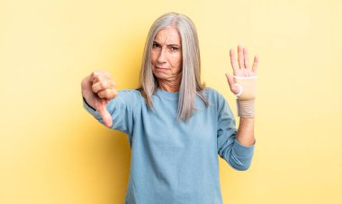 Orta yaşlı, güzel bir kadın kendini kötü hissediyor. el bandajı konsepti