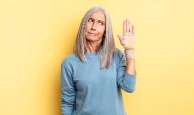 Orta yaşlı, güzel bir kadın üzgün, üzgün ya da kızgın ve yana bakıyor. el bandajı konsepti