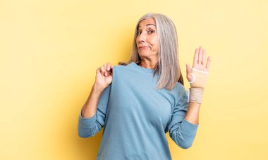 Orta yaşlı, güzel bir kadın kibirli, başarılı, pozitif ve gururlu görünüyor. el bandajı konsepti