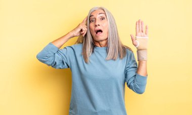 Orta yaşlı, güzel bir kadın şaşırmış görünüyor, yeni bir düşünce, fikir ya da konsept fark ediyor. el bandajı konsepti