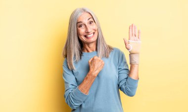 Orta yaşlı, güzel bir kadın kendini mutlu hisseder ve bir meydan okumayla yüzleşir ya da kutlama yapar. el bandajı konsepti