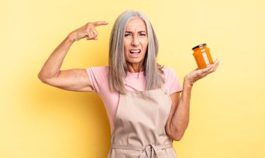 Orta yaşlı güzel bir kadın kafası karışık ve şaşkın hissediyor, deli olduğunu gösteriyor. Şeftali reçeli