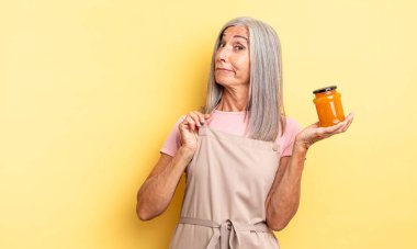 Orta yaşlı, güzel bir kadın kibirli, başarılı, pozitif ve gururlu görünüyor. Şeftali reçeli