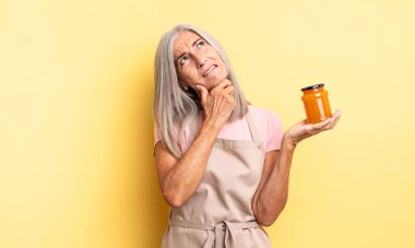 Orta yaşlı, düşünceli, kuşkulu ve kafası karışık bir kadın. Şeftali reçeli