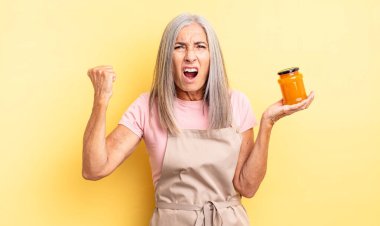 Orta yaşlı, güzel bir kadın sinirli bir ifadeyle agresif bir şekilde bağırıyor. Şeftali reçeli