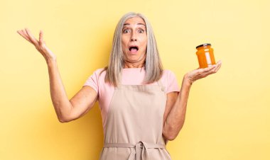 Orta yaşlı güzel bir kadın son derece şaşkın ve şaşırmış hissediyor. Şeftali reçeli