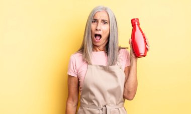 Orta yaşlı güzel bir kadın çok şaşırmış ya da şaşkın görünüyor. Ketçap konsepti