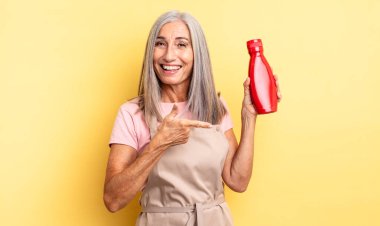 Orta yaşlı, güzel bir kadın heyecanlı ve şaşırmış görünüyor. Ketçap konsepti