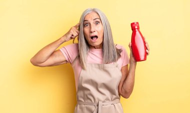Orta yaşlı, güzel bir kadın şaşırmış görünüyor, yeni bir düşünce, fikir ya da konsept fark ediyor. Ketçap konsepti