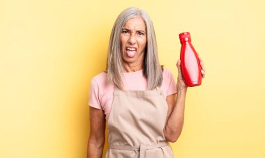 Orta yaşlı, güzel bir kadın iğreniyor, sinirleniyor ve dili dışarı çıkıyor. Ketçap konsepti