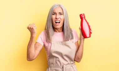 Orta yaşlı, güzel bir kadın sinirli bir ifadeyle agresif bir şekilde bağırıyor. Ketçap konsepti