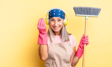 Orta yaşlı, güzel bir kadın kapiş ya da para hareketi yapıp sana ödemeni söylüyor. ev ve süpürge kavramı