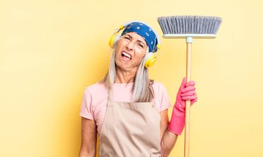 Orta yaşlı, güzel bir kadın şaşkın ve kafası karışık hissediyor. ev ve süpürge kavramı